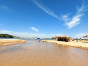 uma praia com um corpo de água com pessoas nela em Rancho peixe grande em Sao Miguel do Araguaia