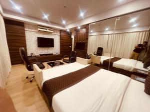 a bedroom with a large white bed and a tv at The Pearl - Couple Friendly in Lucknow