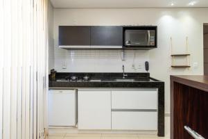 uma cozinha com um lavatório e um micro-ondas em Conforto e Praticidade no Alto da Glória ESP2906 em Goiânia