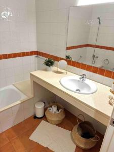 a bathroom with a sink and a tub and a mirror at Apartamento St Agustí - Centro in Mataró