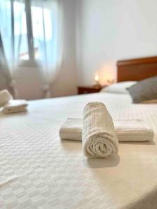 dos toallas sentadas encima de una cama en Apartamento St Agustí - Centro, en Mataró