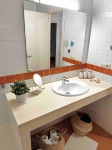 W łazience znajduje się umywalka i lustro. w obiekcie Apartamento St Agustí - Centro w mieście Mataró