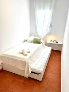 a white bed in a room with a window at Apartamento St Agustí - Centro in Mataró