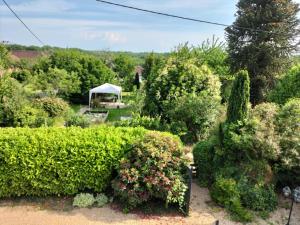 a garden with a gazebo and some bushes and trees at maison en pierre chaleureuse in Jumilhac-le-Grand