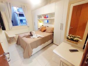 a small bedroom with a bed and a window at AP Top na Praia da Costa in Vila Velha