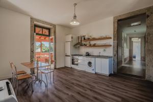 a kitchen and dining room with a table and a table and chairs at Quinta Calheiros - Rural Place in Coucieiro
