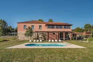 a large house with a swimming pool in the yard at Quinta Calheiros - Rural Place in Coucieiro