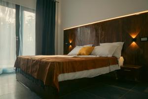 Schlafzimmer mit einem großen Bett mit einem Kopfteil aus Holz in der Unterkunft Villa Taouzert in Tozeur
