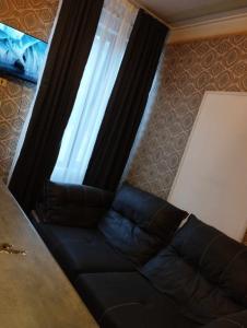 eine schwarze Couch vor einem Fenster in der Unterkunft GuestHouse Oni-Li in Oni