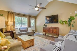 a living room with couches and a flat screen tv at Charming Arkansas Retreat with Deck, Near Downtown! in Fayetteville