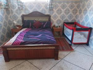 a bedroom with a wooden bed and two night stands at Riad Sidi Rahal Beach in Sidi Rahal