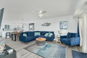 a living room with blue couches and a kitchen at 7080 - Atlantic Paradise by Resort Realty in Rodanthe