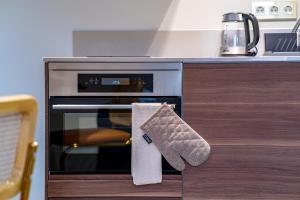 una cocina con horno y una toalla colgada. en New Family top floor apartment Utopia 10min to Rotterdam central city app5, en Schiedam