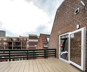 uma varanda com uma porta e um edifício de tijolos em New Family top floor apartment Utopia 10min to Rotterdam central city app5 em Schiedam