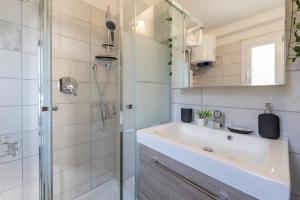 une salle de bain avec lavabo et douche dans l'établissement La Maison Paradiso - vista panoramica & giardino, à Alpette
