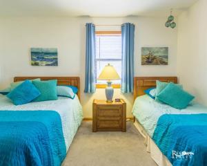 - une chambre avec 2 lits et une lampe sur une table de chevet dans l'établissement 7102 - Sweet Haven by Resort Realty, à Waves