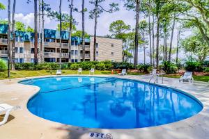 a large pool with chairs and a building in the background at Spa On Port Royal Sound 2217 in Hilton Head Island