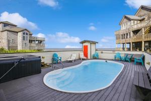 - un bain à remous sur une terrasse avec des chaises et des tables dans l'établissement 7130 - Sunset Breeze by Resort Realty, à Waves