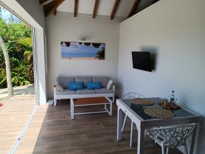 a living room with a couch and a table at Soley Bungalows Nonis 2 pers Adult only in Sainte-Anne