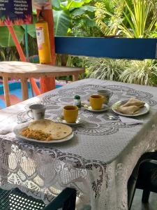 a table with plates of food and cups on it at Eco-Cafe El Mirador in Guachaca +33 photos