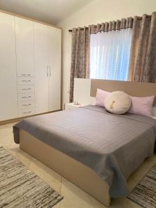 1 dormitorio con 1 cama grande con almohadas rosas en Rooms for rent Gezim Ismailaj, 