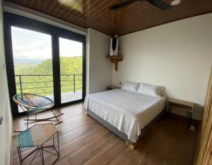sypialnia z łóżkiem i dużym oknem w obiekcie AVANI Boutique Hotel w mieście Norcasia