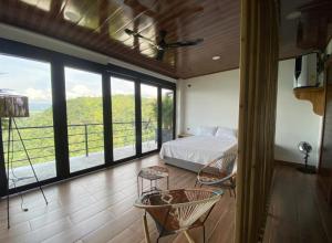 a bedroom with a bed and a balcony with windows at AVANI Boutique Hotel in Norcasia