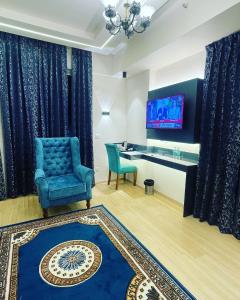 a living room with a blue chair and a desk at Neel Skye - Couple Friendly - DLF My Pad, Gomtinagar , Lucknow in Lucknow