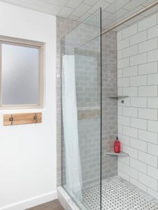 a glass shower in a bathroom with a window at Folly Vacation Great Location, Super Cute & Spacious Apt B in Folly Beach