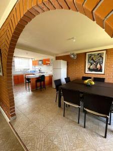 a kitchen and dining room with a table and chairs at Hermosa y lujosa cabaña familiar in Chachagüí