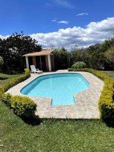 ein Schwimmbad in der Mitte eines Gartens in der Unterkunft Hermosa y lujosa cabaña familiar in Chachagüí