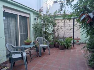 een patio met 2 stoelen en een tafel en een aantal planten bij L&J Departamento in Gerli