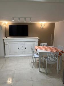 Un comedor con una mesa con sillas y un televisor. en LiFe house, en Nápoles