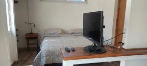 a television sitting on a table in a bedroom at Pequeña casa en chacras de coria in Chacras de Coria
