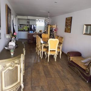 a living room with a table and chairs and a kitchen at Casa Raices in Quito