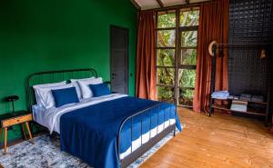 a bedroom with a bed with a green wall at L’akva village in Lagodekhi