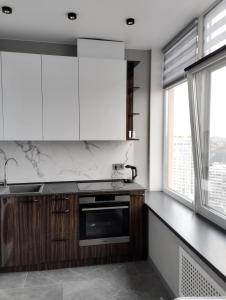 a kitchen with wooden cabinets and white appliances at Board apart hotel in Odesa