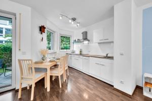 a kitchen with white cabinets and a table and chairs at Wohnung im Herzen Münchens nähe Hauptbahnhof in Munich