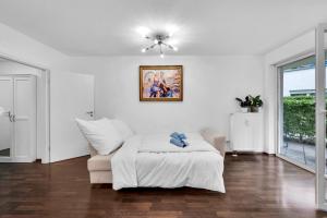 a white living room with a bed and a ceiling fan at Wohnung im Herzen Münchens nähe Hauptbahnhof in Munich