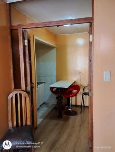 a small room with a table and a red chair at Aquamarina Apart Hotel in Viña del Mar