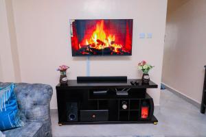 sala de estar con chimenea y TV en la pared en Luxe Happy Home 254 Furnished Apartments en Nairobi
