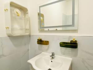 Baño blanco con lavabo y espejo en Luxury Morden 4 bedroom Flats which will make you unforgettable, en Londres