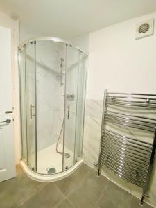 y baño con ducha y mampara de cristal. en Luxury Morden 4 bedroom Flats which will make you unforgettable, en Londres