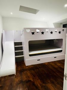 a white bunk bed with black stars on it at Luxury Morden 4 bedroom Flats which will make you unforgettable in London