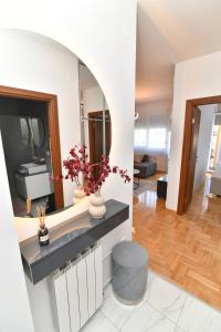 a living room with a sink and a mirror at Apartman Dina in Pirot
