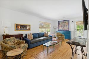 a living room with a blue couch and chairs at Folly Vacation Vintage Cottage 317 East in Folly Beach