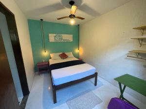 a small bedroom with a bed and a ceiling fan at Maresia Hostel Paraty BR in Paraty