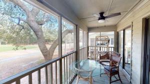 a screened porch with a table and chairs and a tree at Pawleys Plantation Greens 1BR Retreat in Pawleys Island