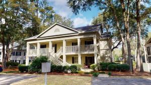 a large yellow house with a white porch at Pawleys Plantation Greens 1BR Retreat in Pawleys Island
