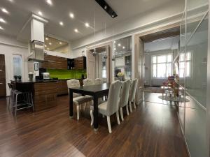 - une cuisine et une salle à manger avec une table et des chaises dans l'établissement St3 Apartman Szeged, à Szeged
